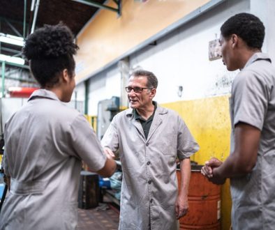 Auto mechanic man greeting his assistants on a repair shop