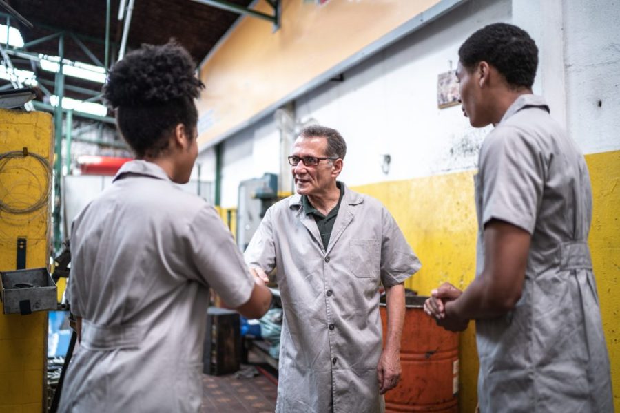 Auto mechanic man greeting his assistants on a repair shop
